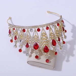 Close-up of golden baroque tiara with red crystal drops and white rhinestones