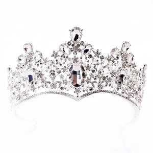 Close-up of baroque silver bridal crown with large oval crystal and teardrop rhinestones