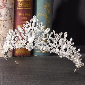 Close-up of Baroque silver bridal crown with leaf patterns, zircons and white pearls