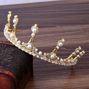 Detail of elegant gold bridal crown with white pearls and rhinestones on a vintage box