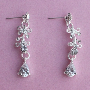 Detail view of silver bridal earrings featuring teardrop cubic zirconia and vine patterns