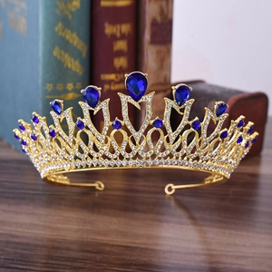 Close-up of golden bridal crown featuring teardrop blue gems and intricate rhinestones