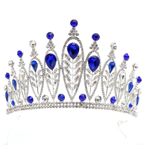 Close-up of baroque silver bridal tiara with sparkling crystal leaves and dark blue gems