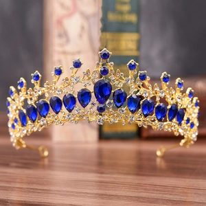 Détails de couronne dorée avec cristaux bleus en goutte sur un bureau vintage élégant