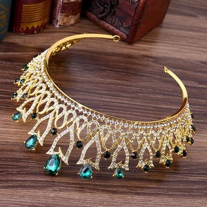 Detailed close-up of a vintage golden crown with emerald green teardrop gemstones