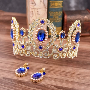 Baroque bridal jewelry set with golden crown, blue crystals and pearls on wood background
