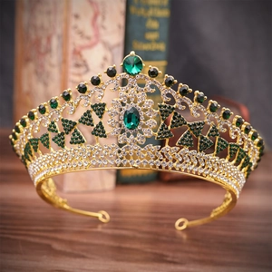 Macro shot of vintage gold alloy crown featuring emerald gemstones and sparkling rhinestones