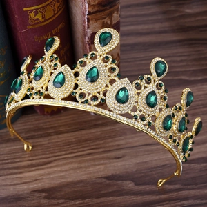 Detail of emerald green crystal wedding crown with gold metal base on vintage books