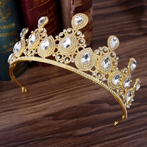 Close-up of golden bridal crown with intricate rhinestones and pear-cut crystal drops