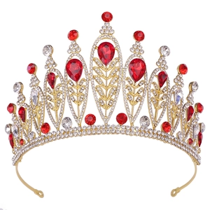 Detailed macro view of baroque crown featuring red teardrop gems and silver leaf metalwork