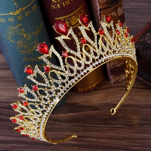 Close-up of golden bridal crown with red gems and crystals on vintage book backdrop