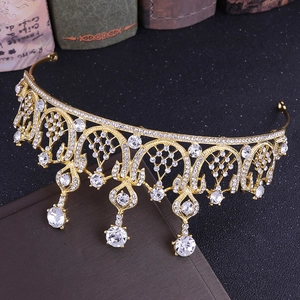 Dettaglio corona dorata con strass, motivo in pizzo metallico e gemme a goccia brillanti