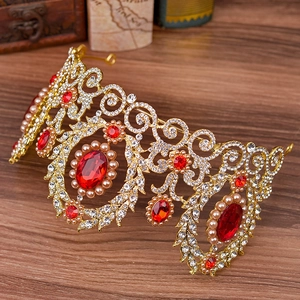 Detail of baroque gold crown with red gems and pearls on a vintage map background