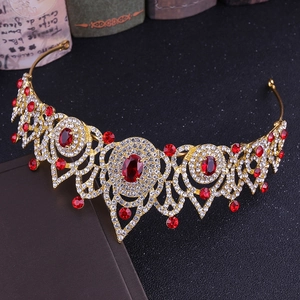 Détail d'une couronne de mariée dorée avec pierres rouges et strass blancs sur noir