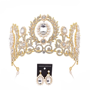 Close-up of golden bridal crown and earrings set with baroque pearls and rhinestones