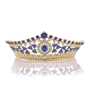 Detailed view of golden tiara with blue and white rhinestones and elegant mirror reflection