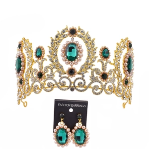 Detailed view of Baroque bridal crown and earrings set with green stones and pearls