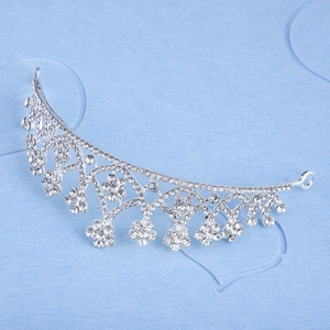 Close-up of elegant silver alloy tiara with sparkling crystal flowers on blue background