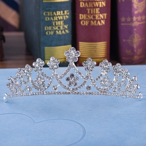Elegant silver bridal tiara with floral rhinestone patterns on vintage book background