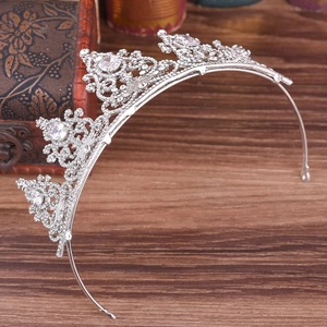 Detail shot of a silver bridal crown with shimmering zircons on a vintage wooden background