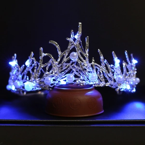 Macro detail of bridal crown with glowing blue LED lights and silver floral branches
