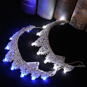 Luxurious bridal crown with LED lights and silver crystals on a black velvet background