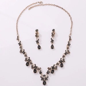 Macro detail of vintage gold bridal jewelry set with dark grey teardrop crystals