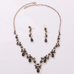 Detail of vintage bronze bridal jewelry set with grey teardrop zircon crystals and leaves