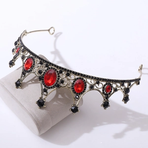 Close-up of vintage bridal crown with red gemstones and black rhinestones detailing