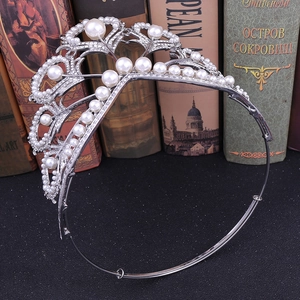 Diadème de mariée argenté avec strass et perles sur fond de livre vintage