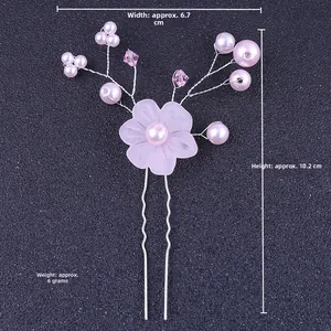Detail of handmade bridal hair pin with pink floral motif, pearls and crystals