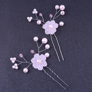 Detailed macro shot of handmade pink flower hair pins with pearls and crystal beads