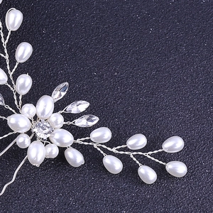 Détail d'épingle à cheveux en fil d'argent avec perles blanches et cristaux pour mariée