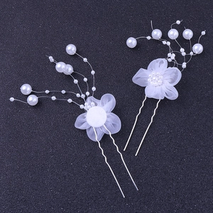 Detail von handgefertigten weißen Spitzenblumen-Haarnadeln mit Perlen und U-förmigen Clips