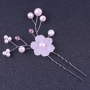 Close-up of pink translucent flower hair pin with pearl and crystal beaded details