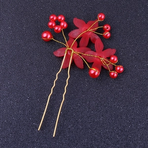 Détail de l'épingle à cheveux de mariée avec fleurs rouges et perles sur fil doré