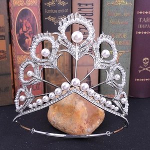 Détail de la couronne de mariée argentée avec motifs de plumes de paon, perles et strass