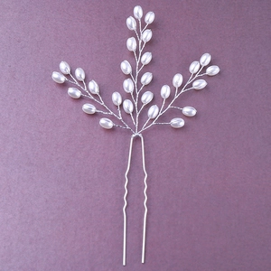 Détail d'épingle à cheveux de mariée avec perles blanches et fil argenté sur fond violet