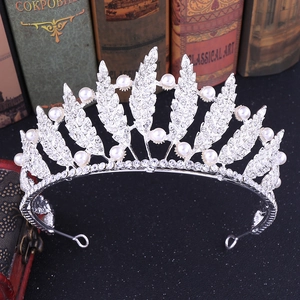 Elegant silver leaf crown with rhinestones and pearls on vintage background
