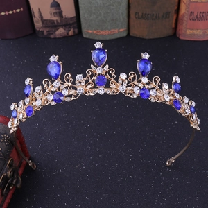 Close-up of golden bridal tiara with blue teardrop stones and white diamonds
