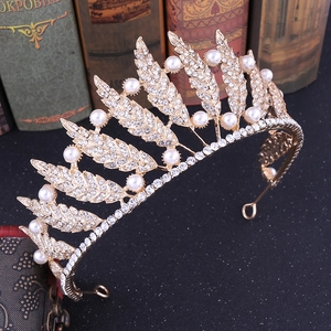 Golden baroque leaf crown with white rhinestones and pearls on vintage book