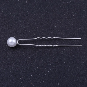Vue détaillée d'une épingle à cheveux en forme de U argentée avec perle et strass