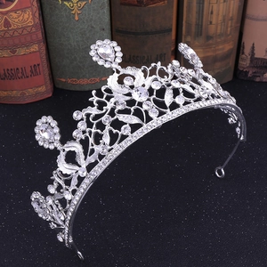 Couronne de mariée argentée avec feuilles et strass scintillants sur un fond noir élégant