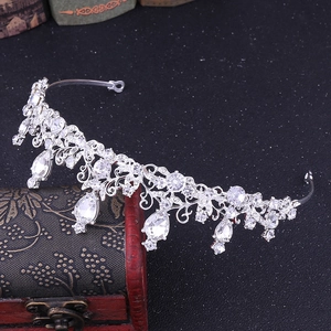 Detailed close-up of a silver bridal tiara featuring intricate vines and teardrop crystals