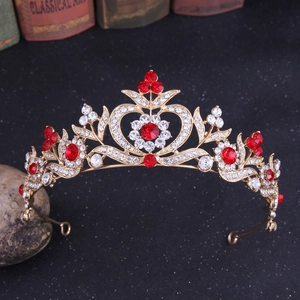 Vue macro détaillée des strass rouges en forme de cœur et de feuille sur la couronne dorée