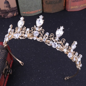 Detail of golden bridal tiara with pear-shaped crystals and vintage leaf patterns