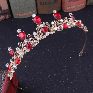 Close-up of golden bridal crown with ruby-colored gems and sparkling rhinestones