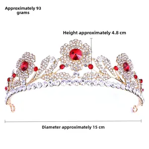 Dettaglio della corona floreale dorata con pietre rosse e strass bianchi brillanti