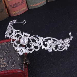 Detailed close-up of a silver bridal crown with intricate crystals on a vintage box