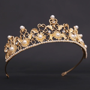 Detailed macro view of vintage gold bridal tiara with pearls and flower leaf crystals